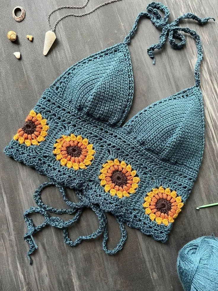 a blue crocheted top with sunflowers